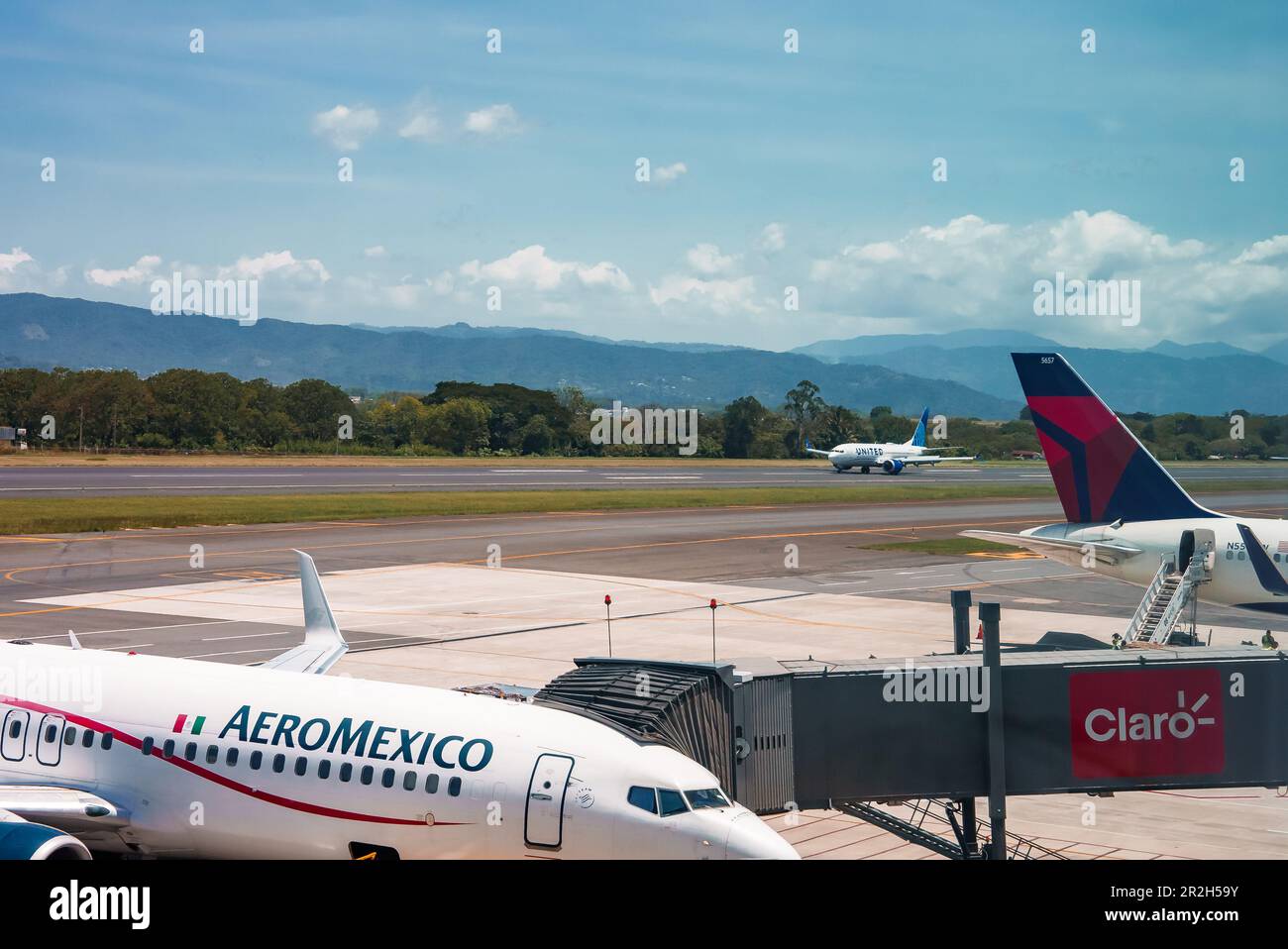 Busy airport view with airplanes and service vehicles in Costa Rica