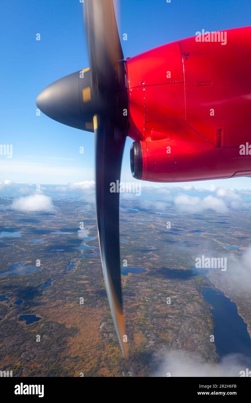 Photo of the nose of a prop plane with propeller spinning while flying