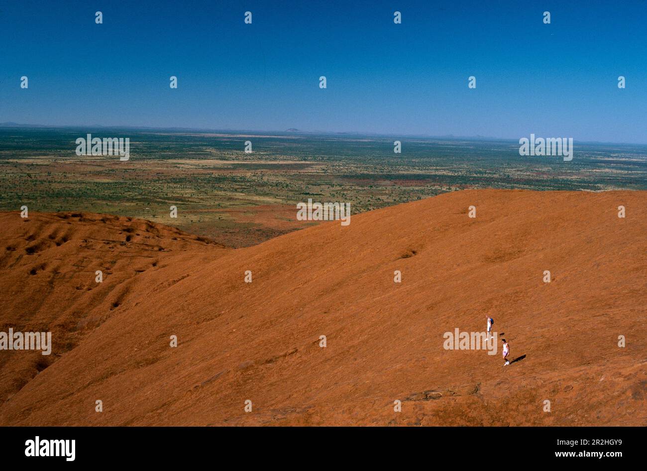 Hikers climbing Ayers Rock, Northern Territory, Australia Stock Photo