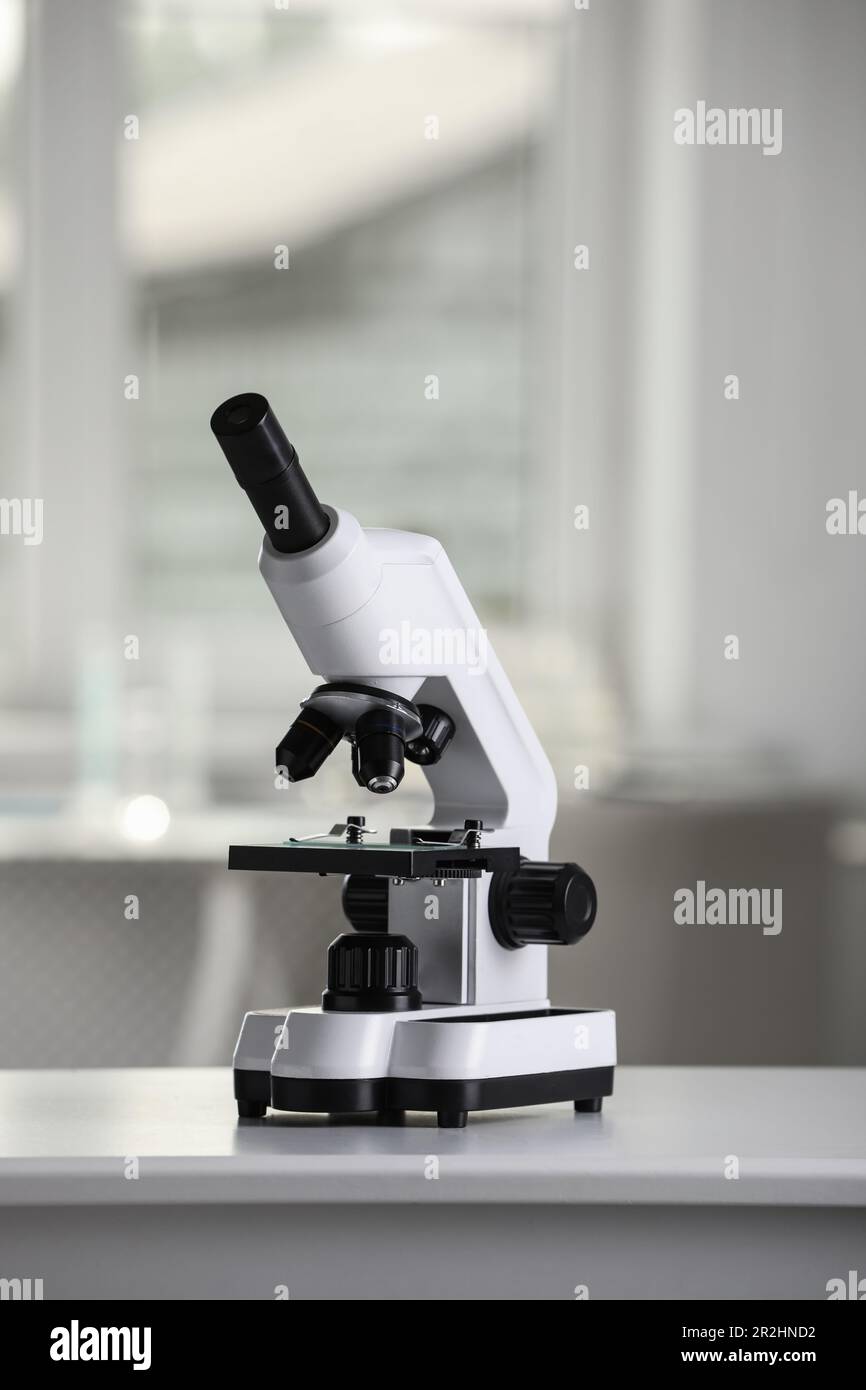 Modern medical microscope on white table in laboratory Stock Photo - Alamy