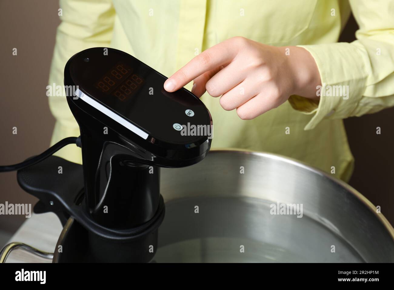 Sous vide cooking. Woman using thermal immersion circulator, closeup Stock Photo Alamy