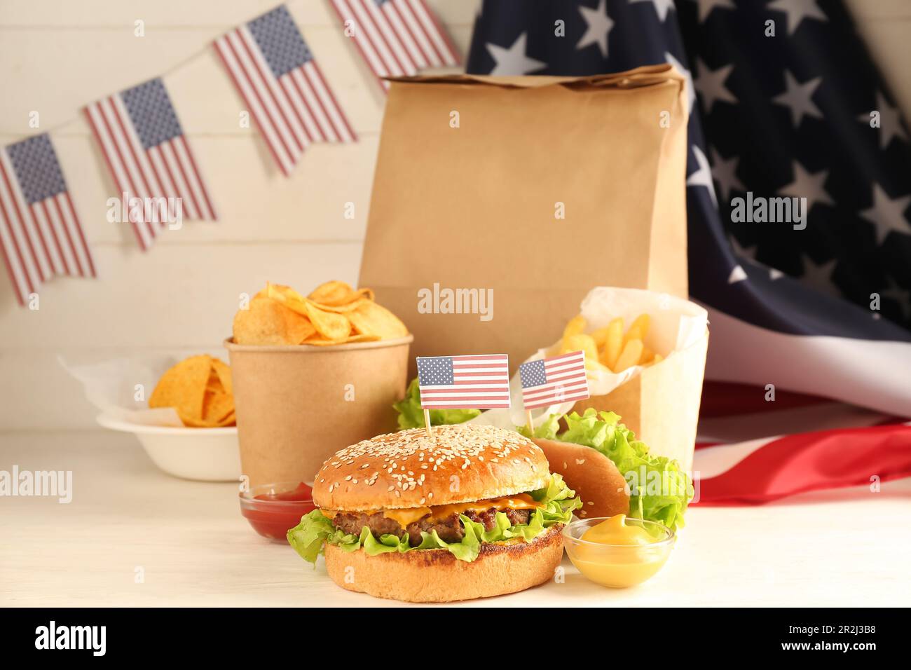 Tasty food for Memorial Day celebration and American flag on light table Stock Photo