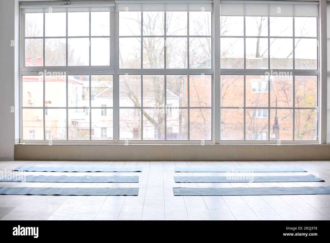 Yoga mats on floor near window in gym Stock Photo Alamy