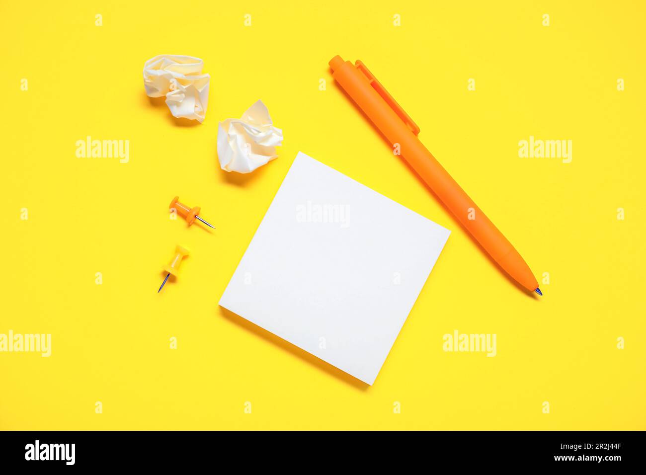 Pen with sticky notes and pins on yellow background Stock Photo