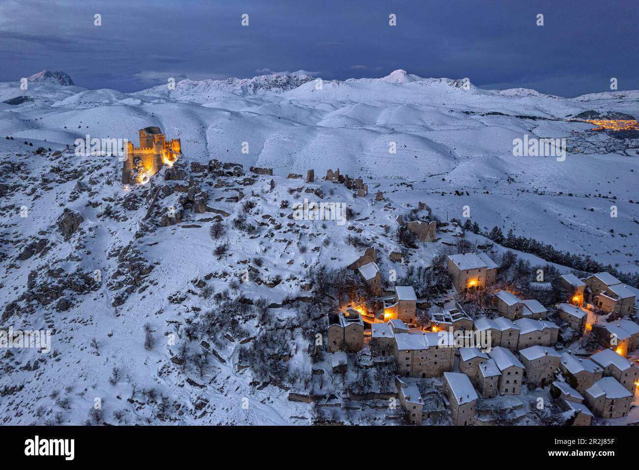 Winter view of the snow covered illuminated medieval village of Rocca Calascio with the castle at dusk, Rocca Calascio Stock Photo