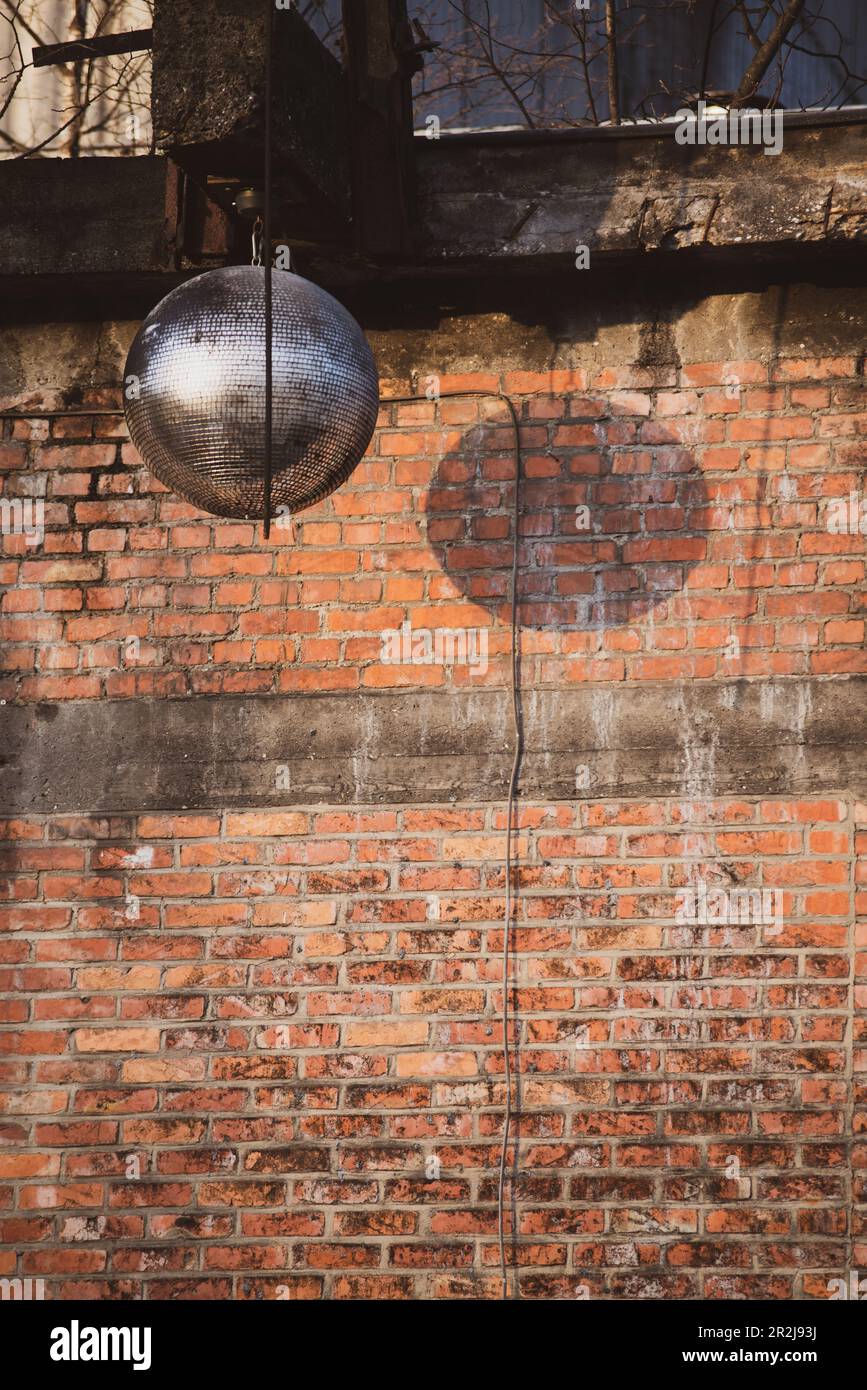 party mirrorball against red brick wall Stock Photo