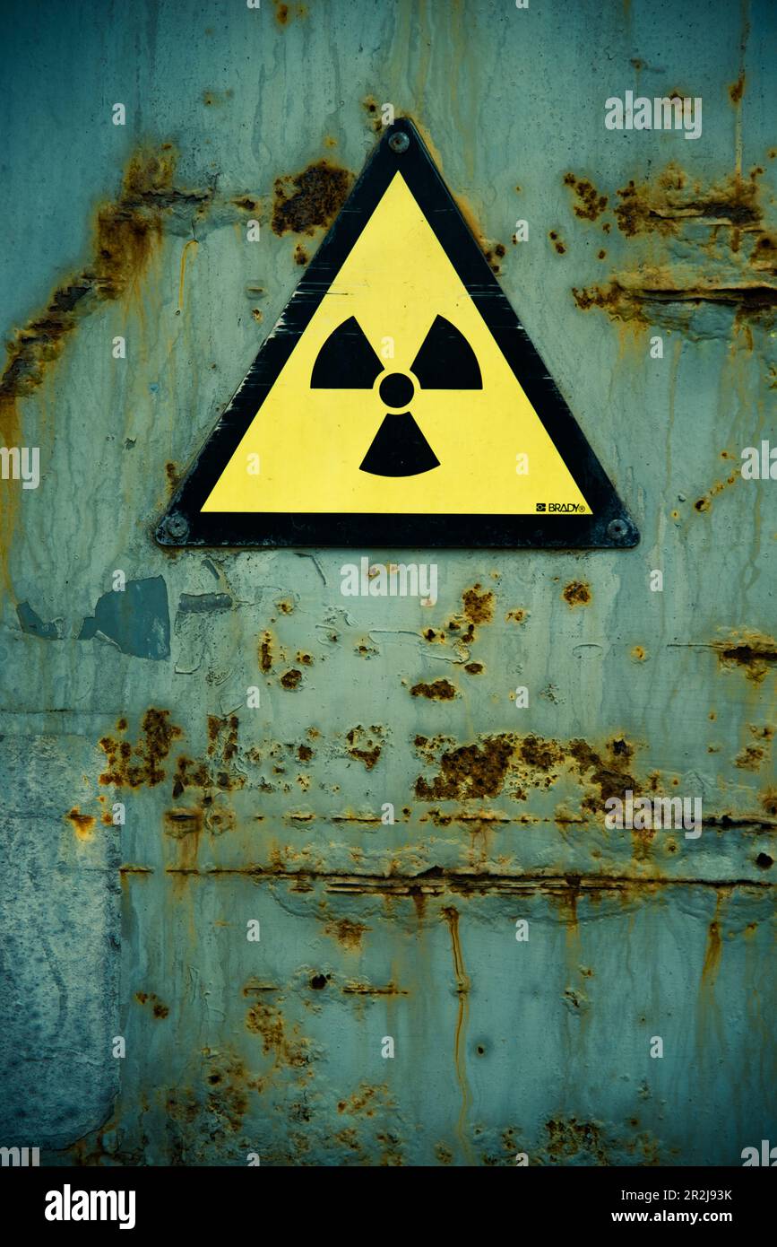 Radiation warning on old rusted door. Stock Photo