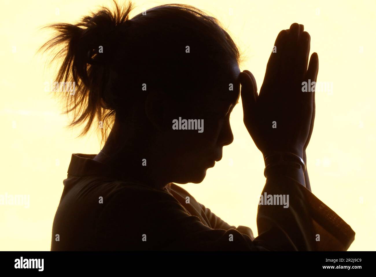 Silhouette of woman praying in temple, Faith and spirituality concept, Vietnam, Indochina, Southeast Asia, Asia Stock Photo