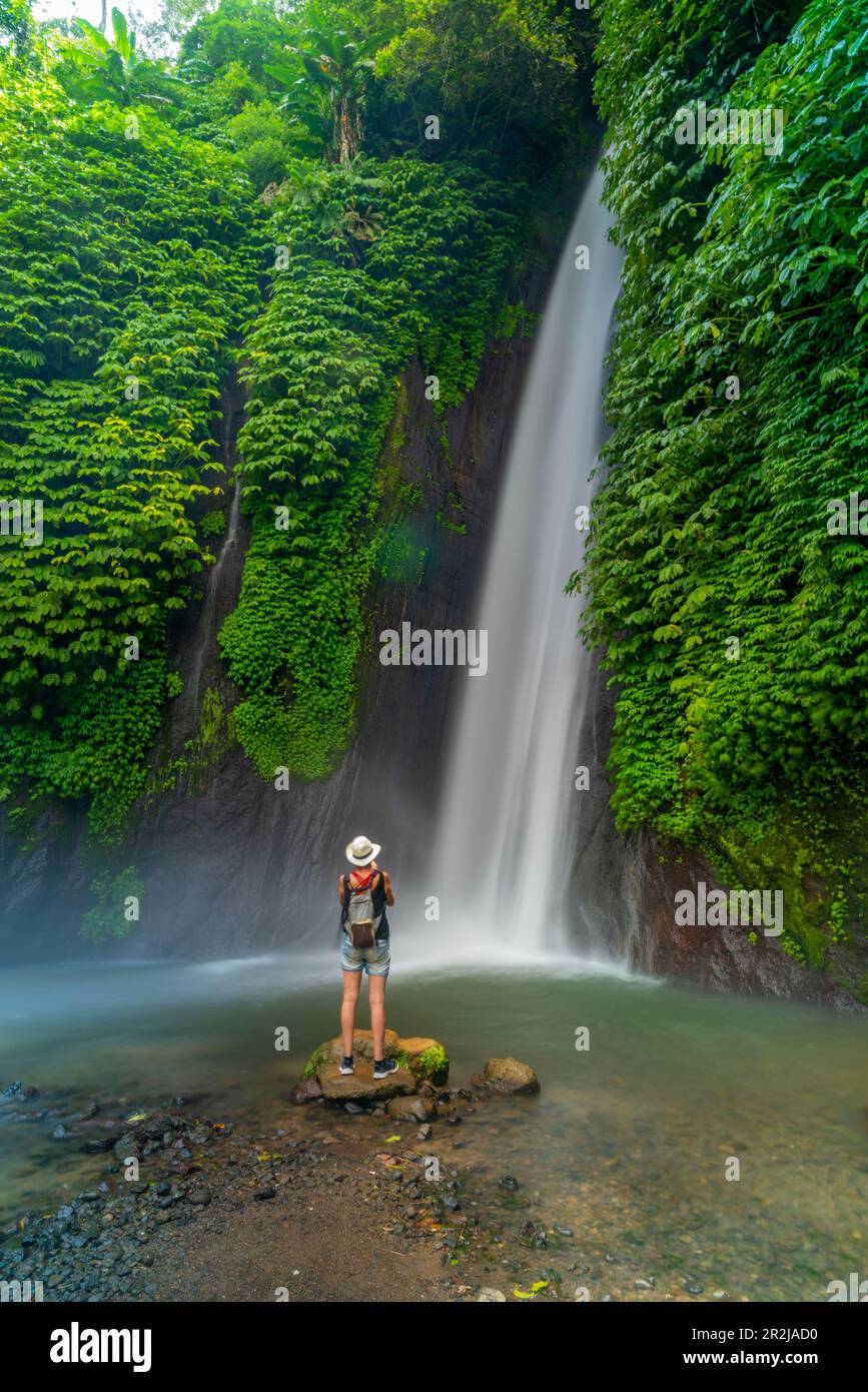 View of woman taking picture at Melanting waterfall, Kabupaten Buleleng, Gobleg, Bali, Indonesia, South East Asia, Asia Stock Photo
