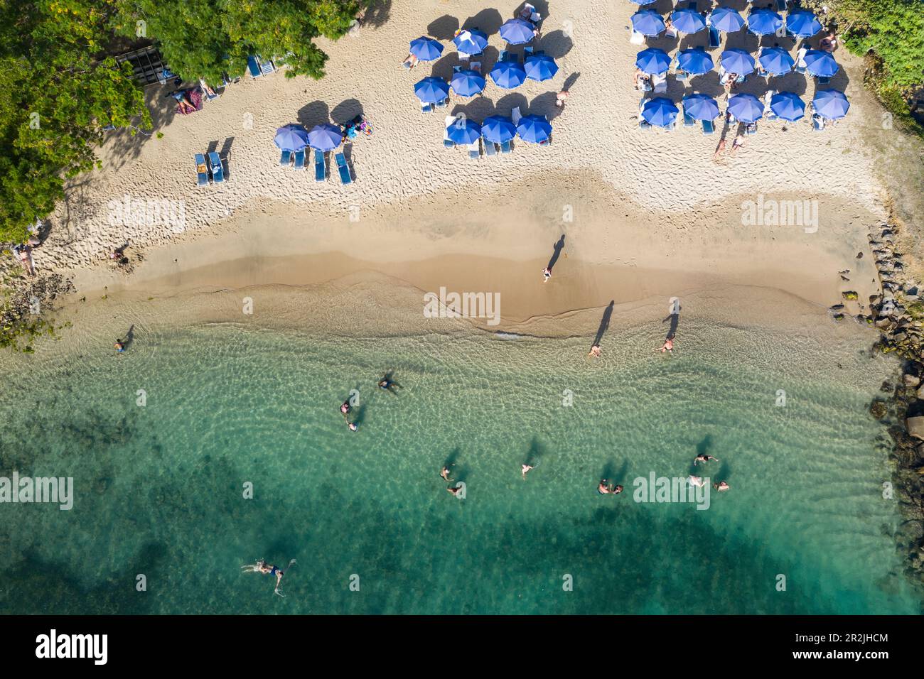 Aerial view of people in the water and umbrellas on the beach at Pigeon