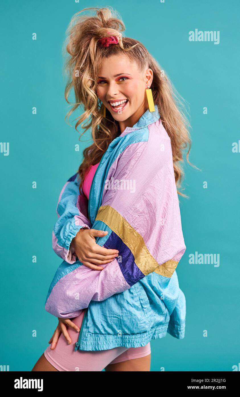 https://c8.alamy.com/comp/2R2JJ1G/80s-fashion-retro-style-and-woman-portrait-with-vintage-neon-and-happiness-in-a-studio-blue-background-female-person-and-jacket-of-a-model-with-2R2JJ1G.jpg