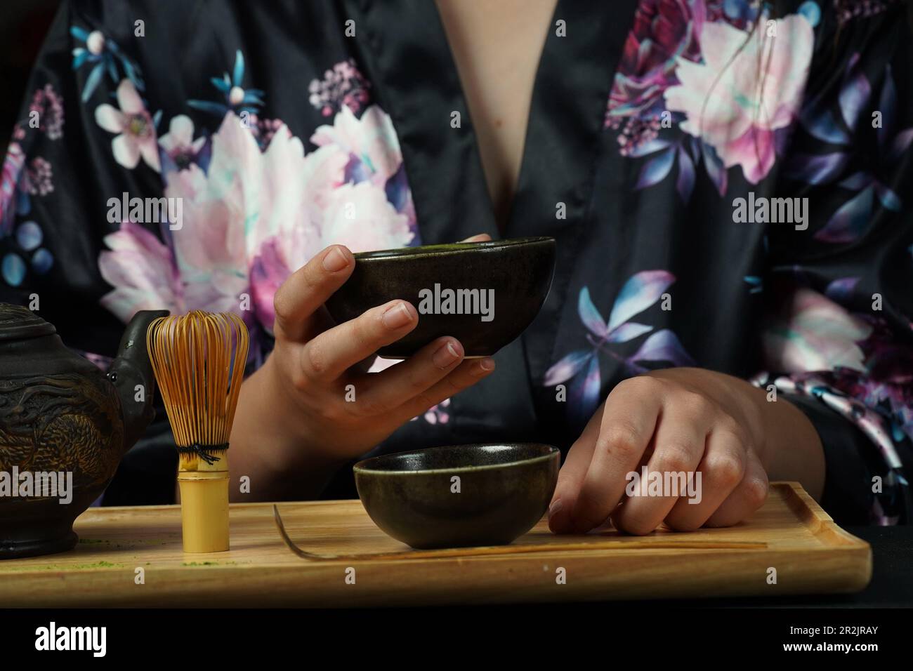 Woman tea master in kimono performs tea ceremony. Matcha green tea