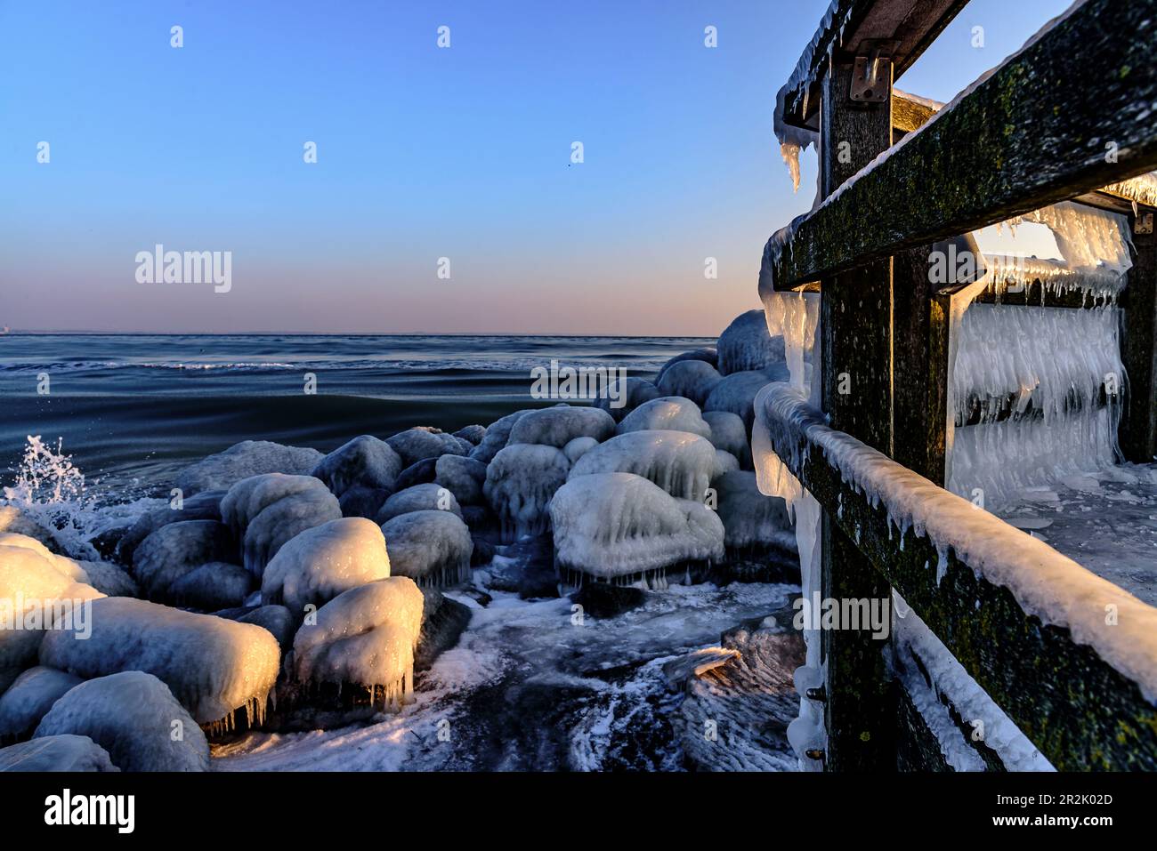 Icy railings and rocks at the port of Niendorf, Bay of Lübeck ...