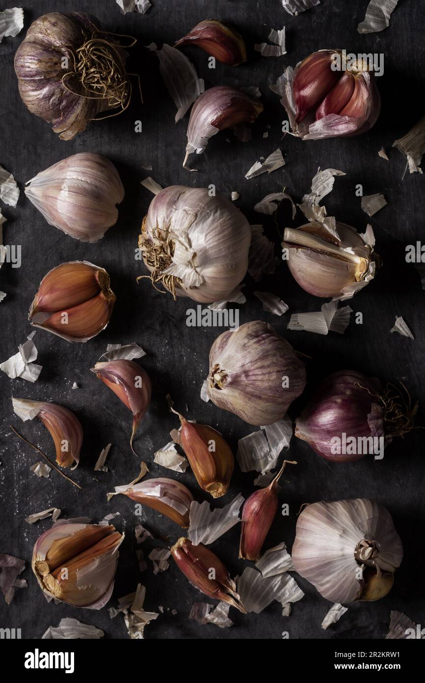 Fresh garlic bulbs and cloves grouped on black background. Flat lay ...