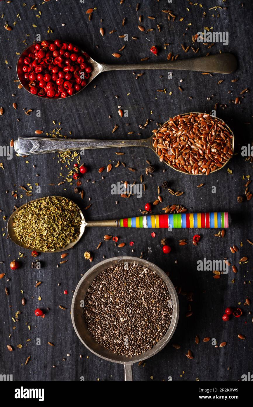 Spices in spoons on black background.