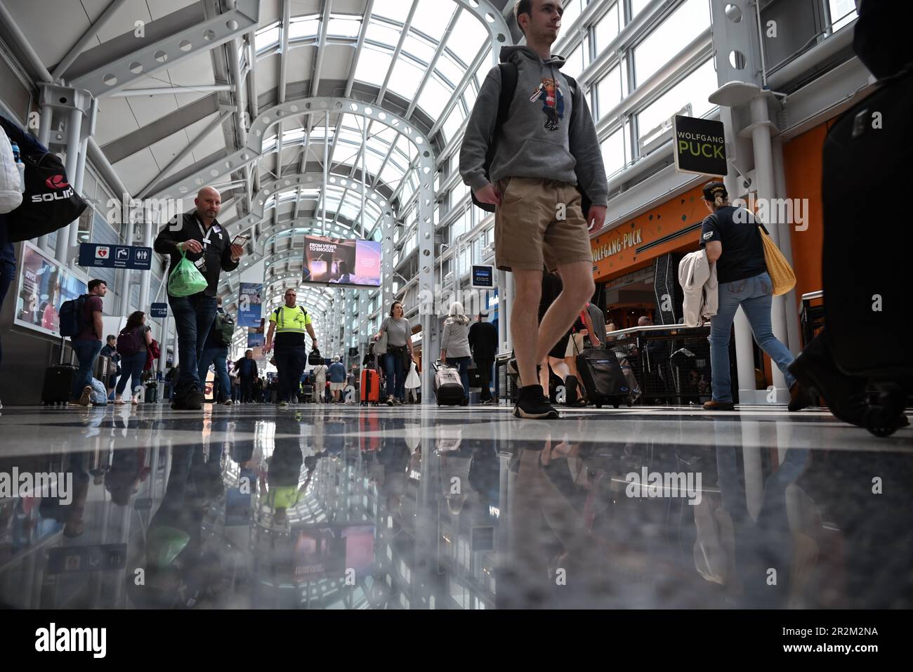 Travelers walk the long hallway between gates in Terminal One of Chicago's O'Hare Airport Stock