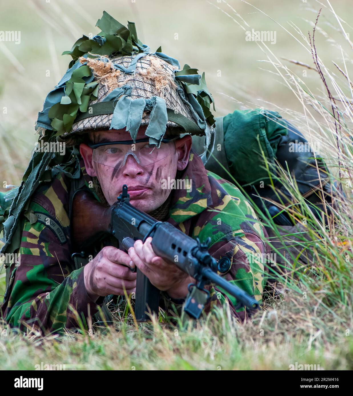 1970 British Army soldier in camouflage suit and steel helmet carrying ...