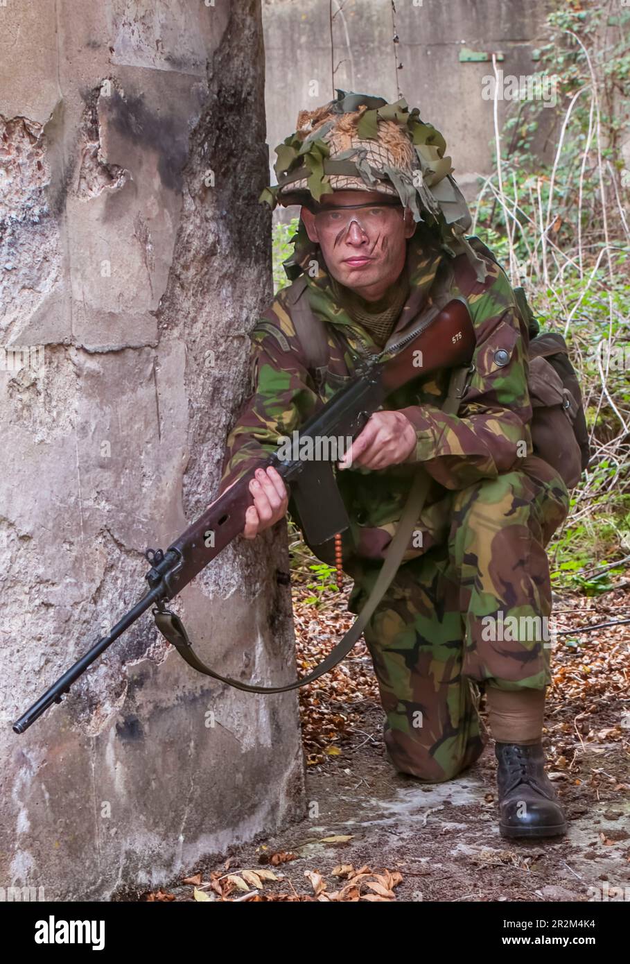 1970 British Army soldier in camouflage suit and steel helmet carrying ...
