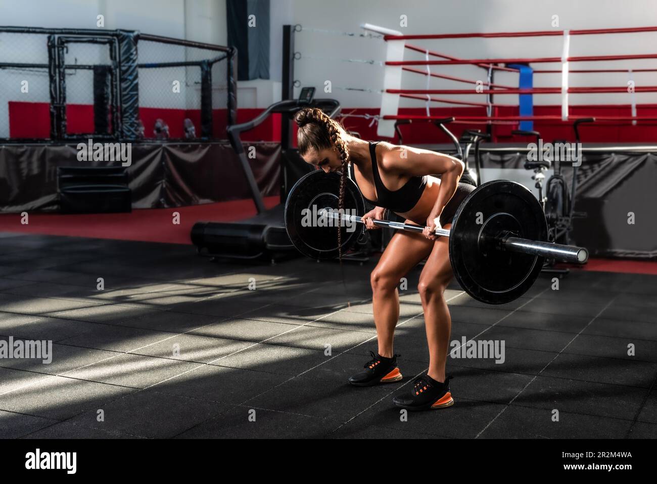 Young sweaty strong muscular bodybuilder woman weightlifting workout