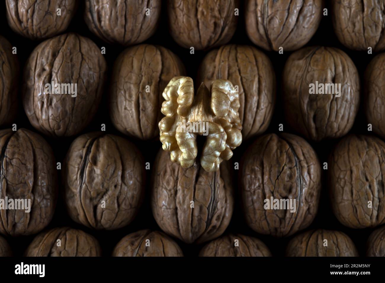 Walnut kernels and cracked walnuts on wooden table Stock Photo