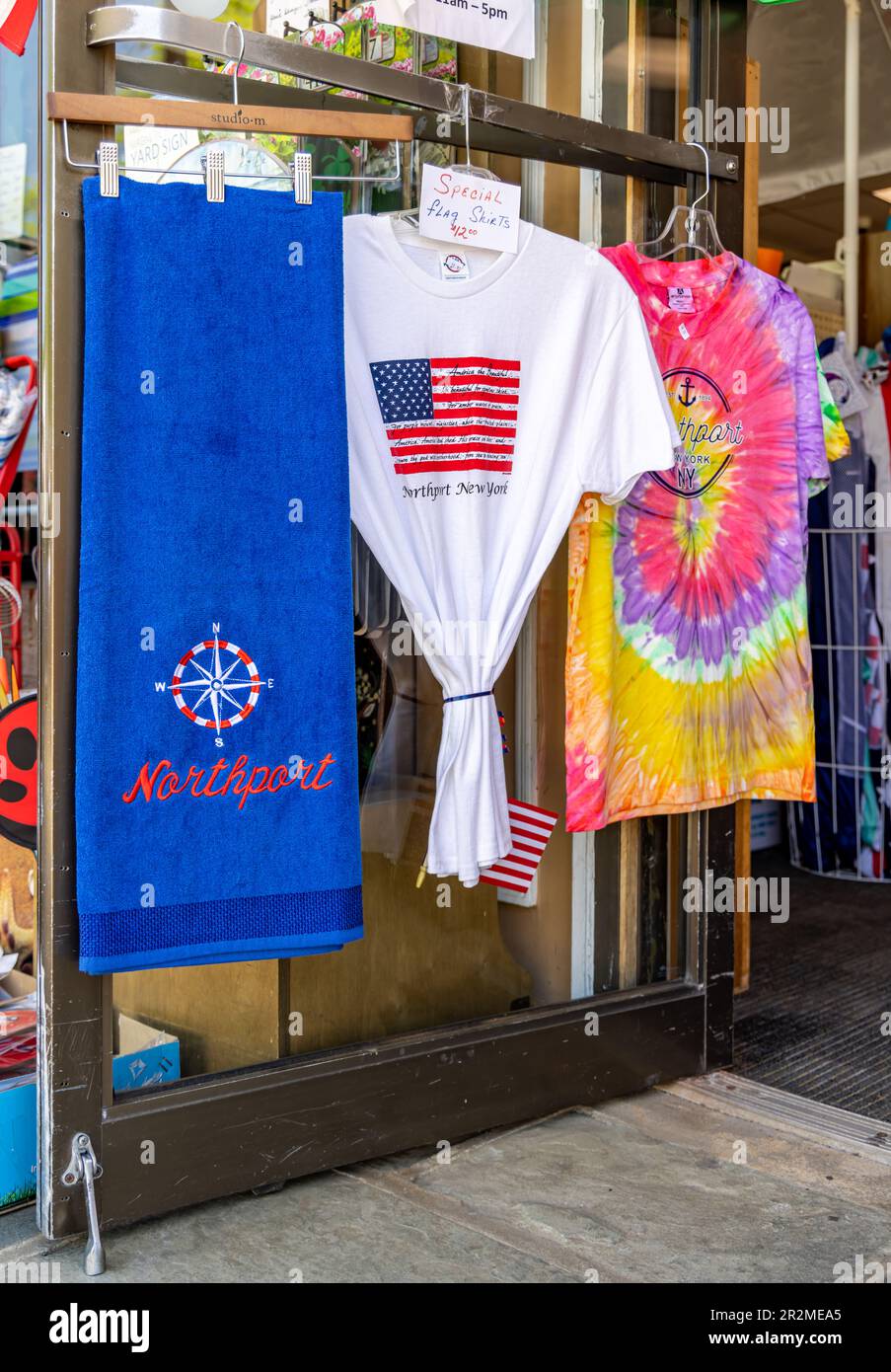 An image of t-shirts and a beach towel on display in a northport store on main street Stock Photo