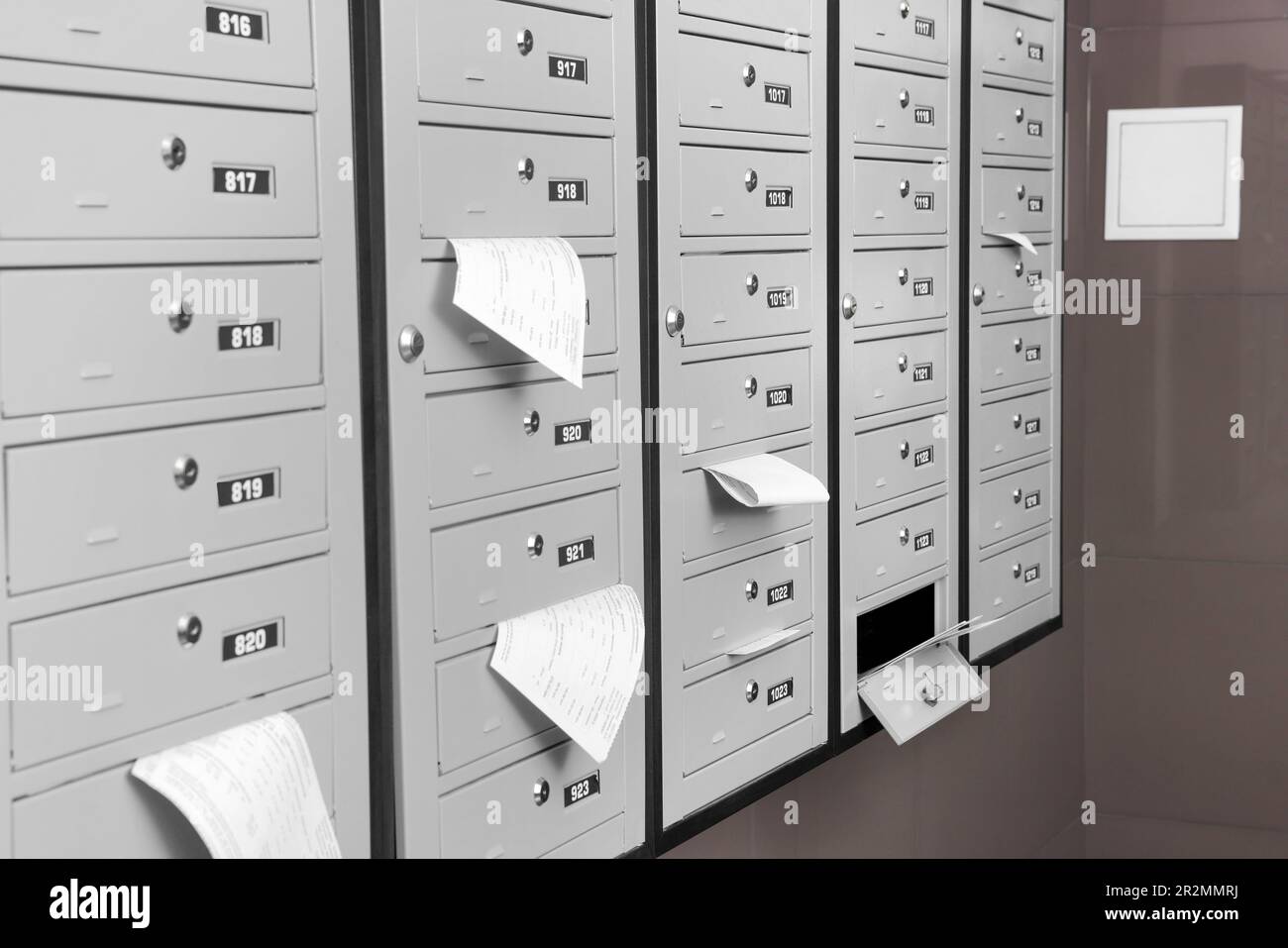 Closed grey metal mailboxes with receipts indoors Stock Photo Alamy