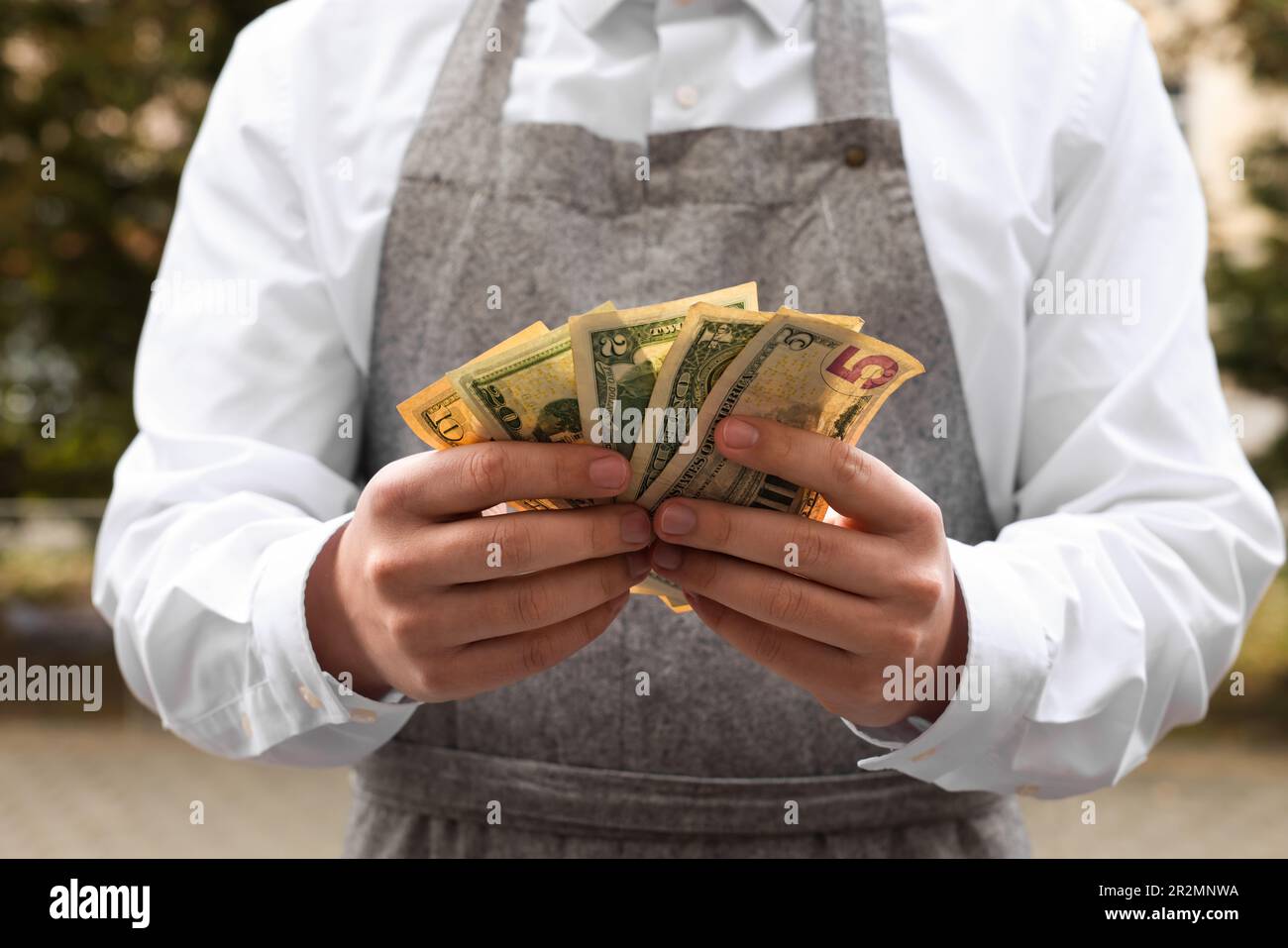 Waiter holding tips in outdoor cafe, closeup Stock Photo