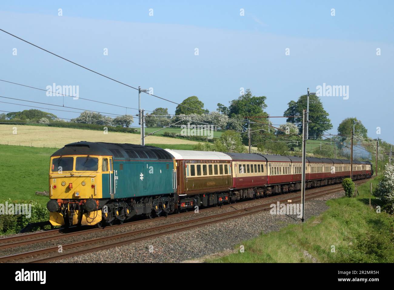Class 47 diesel-electric loco 47614 at rear of The Lakelander special train passing Bay Horse in Lancashire on West Coast Main Line, 20th May 2023. Stock Photo