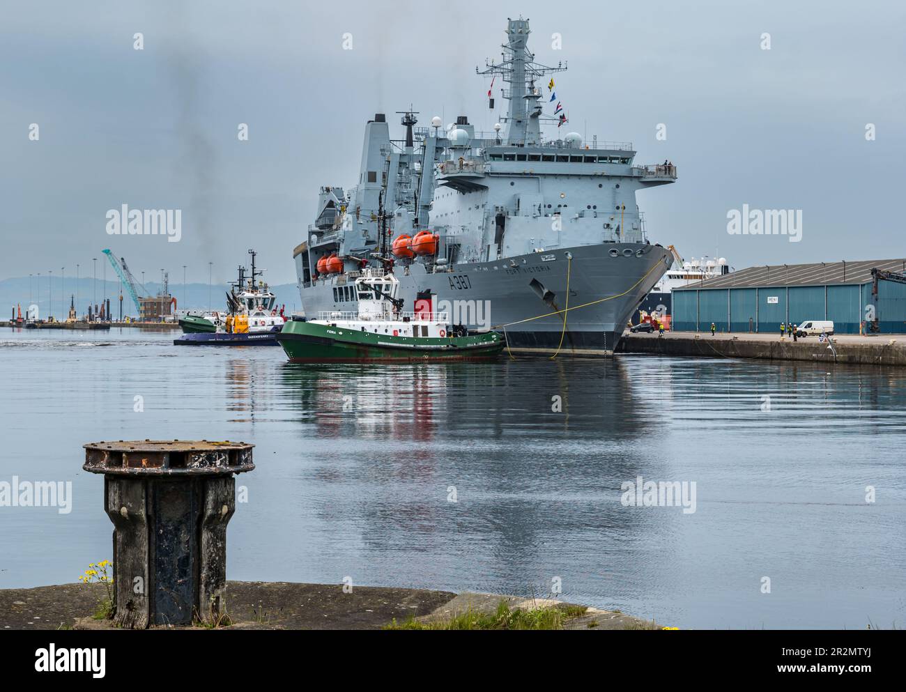 Edinburgh, Scotland, UK, 20th May 2023. RFA Fort Victoria (A387) enters Leith harbour: the combined fleet stores ship and tanker of the Royal Fleet Auxiliary of the United Kingdom tasked with providing ammunition, fuel, food and other supplies to British Royal Navy vessels is manoeuvred into the harbour to a mooring by tug boats. Credit: Sally Anderson/Alamy Live News Stock Photo