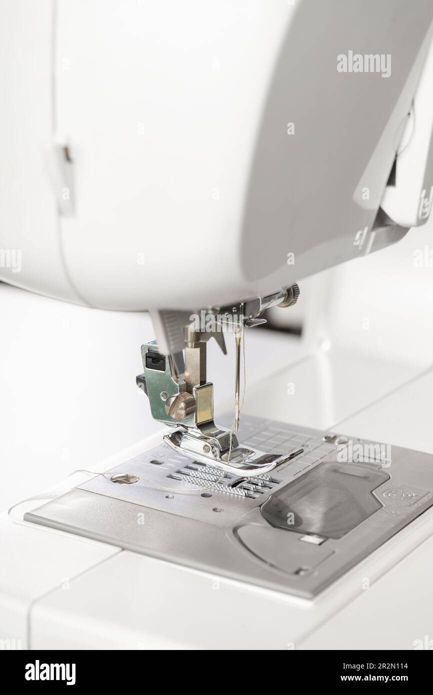 Modern white sewing machine presser foot closeup, macro. Sewing