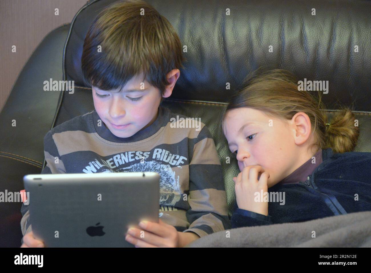 Brother and sister playing on a digtal tablet Stock Photo - Alamy