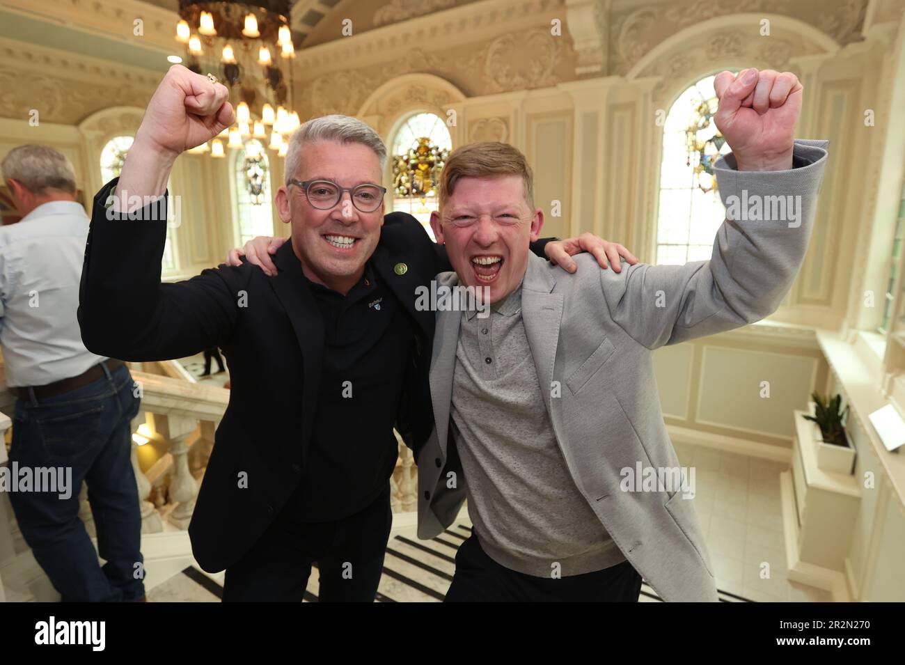 Sinn Fein's Padraig Donnelly (right) and Irish Senator Niall ODonnghaile (left) celebrate winning a seat at the Northern Ireland council elections at Belfast City Hall. Picture date: Saturday May 20, 2023. Stock Photo