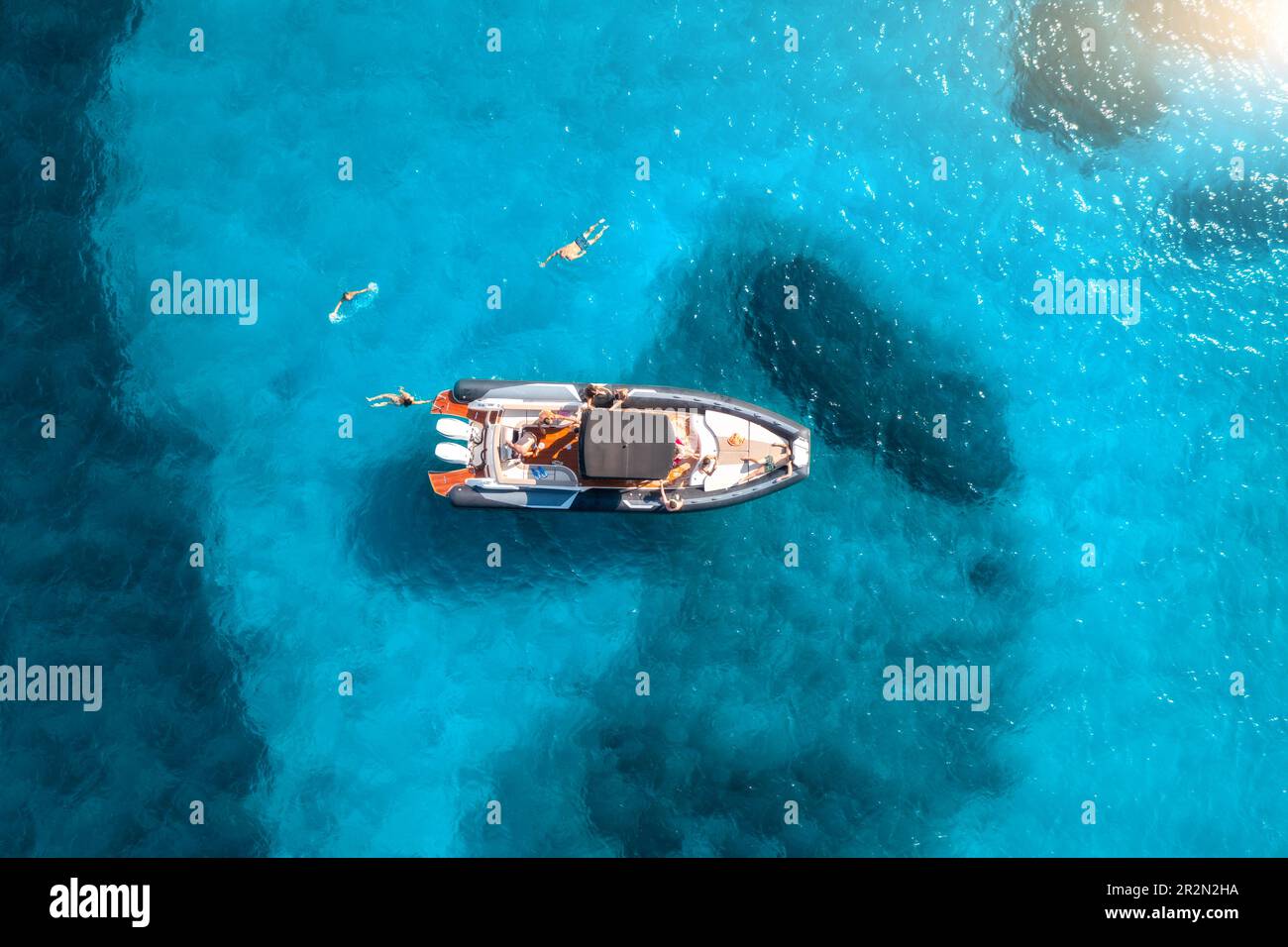 Aerial view of motorboat, swimming people in blue sea at sunset Stock ...