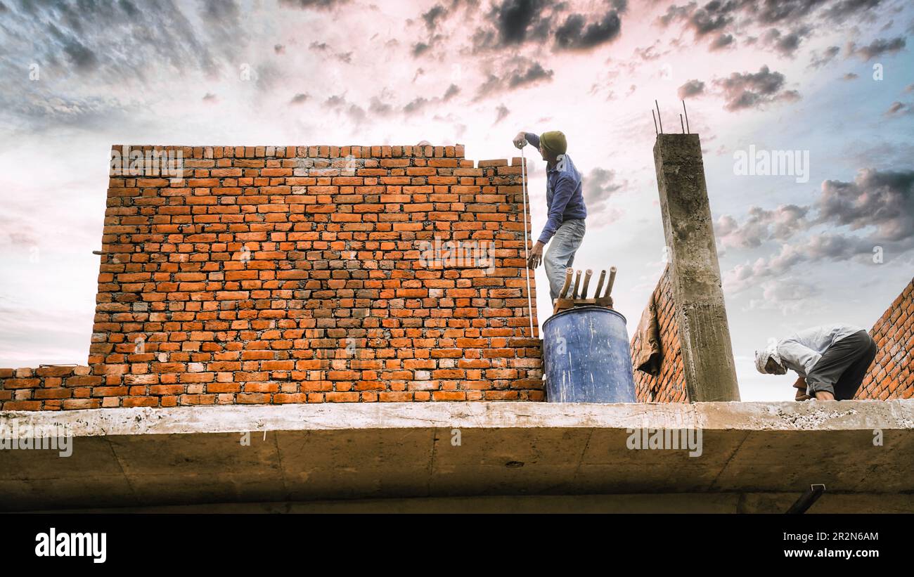 Man checks the accuracy of the walls using a measuring tape. Bricklaying Basics Masonry Techniques. Stock Photo