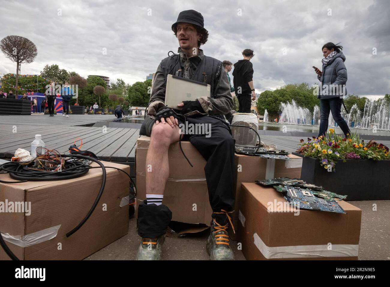 Moscow, Russia. 20th of May, 2023. A young man is sitting on the street with a tablet and computer parts on the days of the Positive Hack Days cyber festival in Gorky Park in Moscow, Russia Stock Photo
