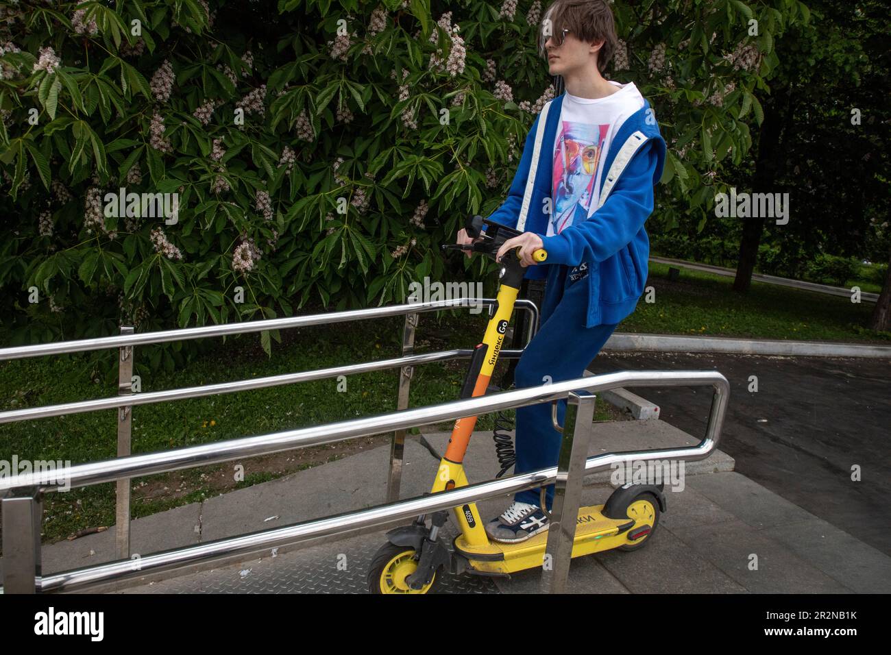 Moscow, Russia. 20th of May, 2023. A young man drives on an electric scooter of the Yandex Go rental service in Gorky Park in Moscow, Russia Stock Photo