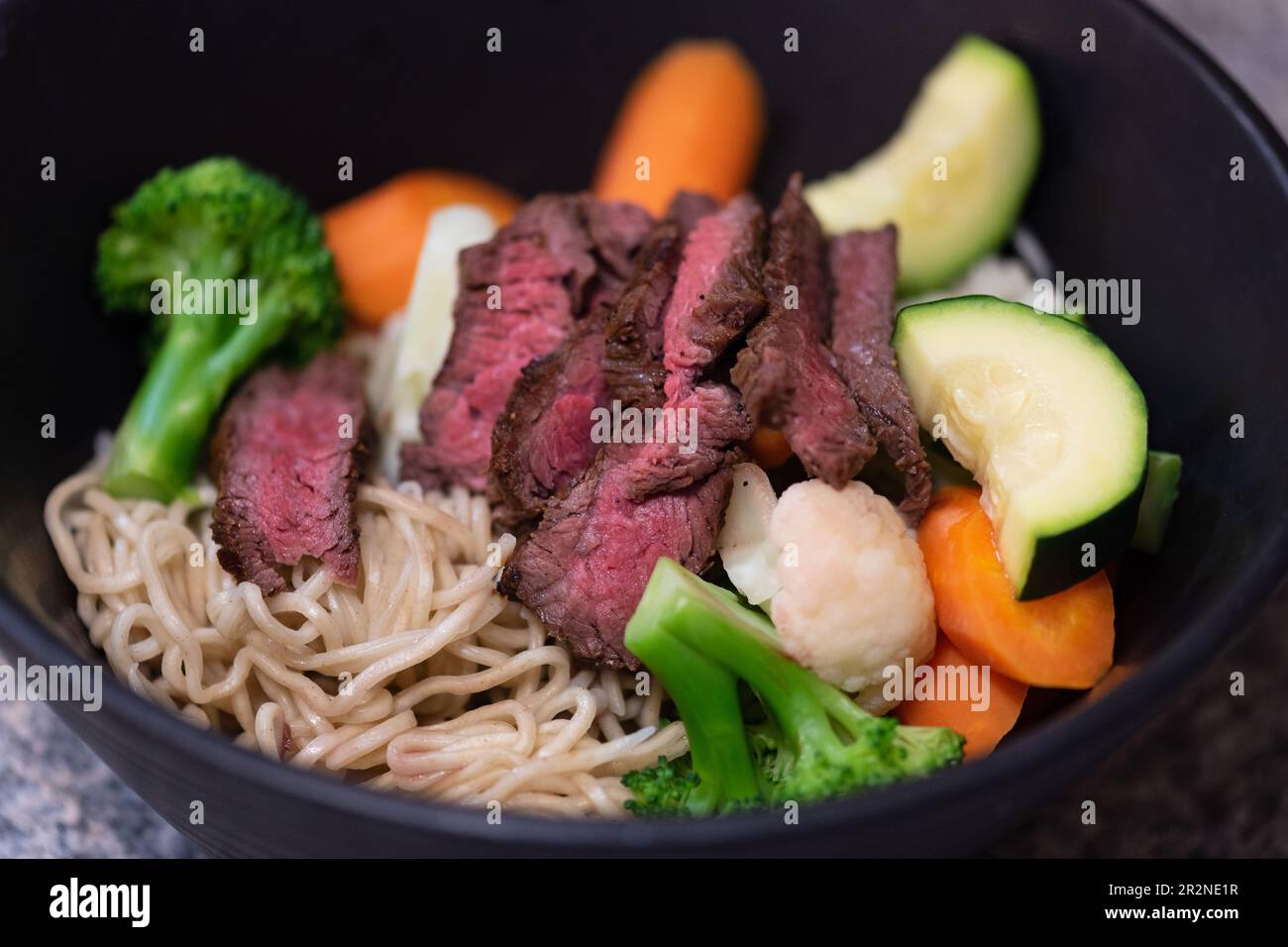 Grilled beef Steak and summer vegetable Asian styled Ramen noodle soup bowl. Stock Photo