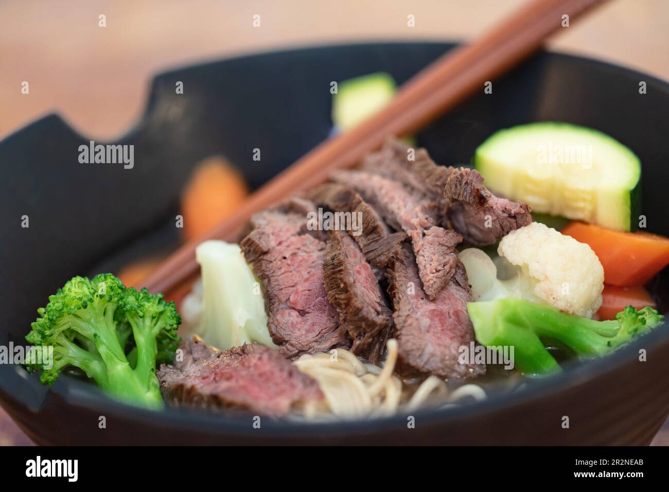 Grilled beef Steak and summer vegetable Asian styled Ramen noodle soup bowl. Stock Photo