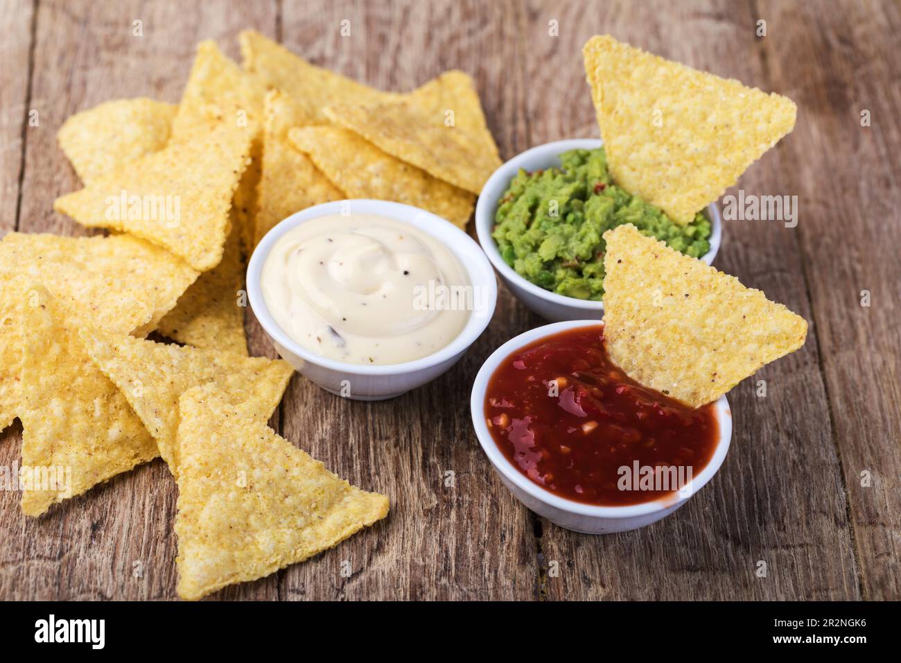 Corn chips nachos with sauce on a wooden table Stock Photo