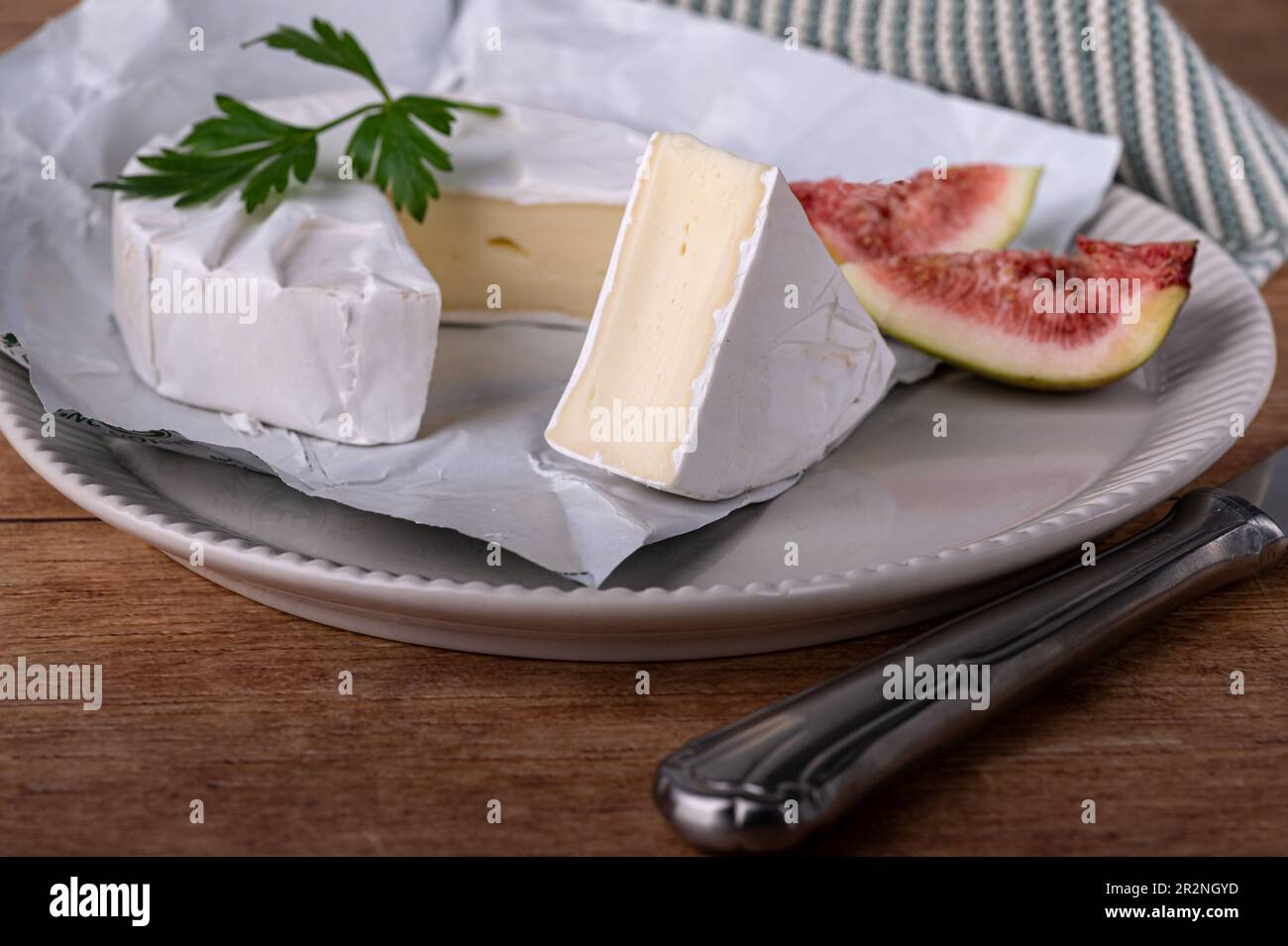 Sliced soft cheese on a plate with figs Stock Photo