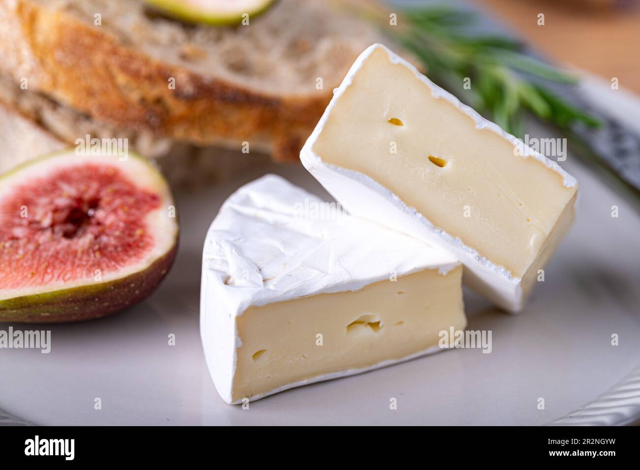 Sliced soft cheese on a plate with figs Stock Photo