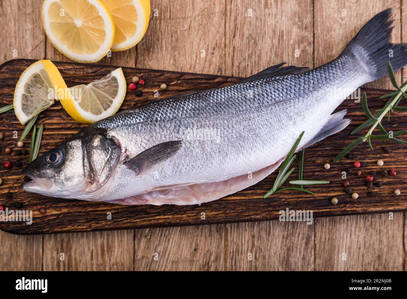 Raw Seabass isolated on a wooden table Stock Photo