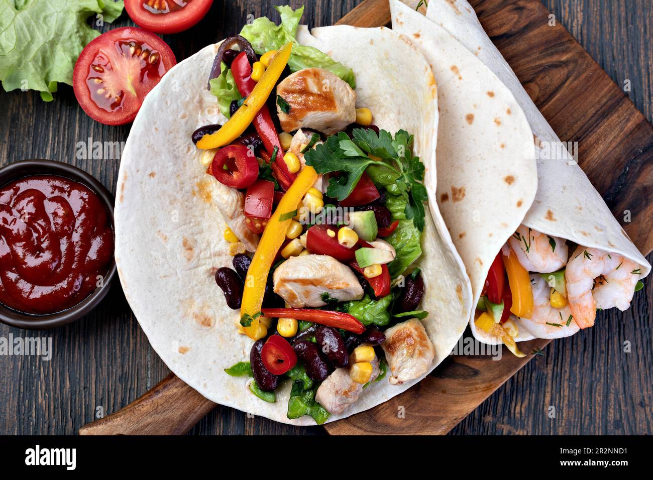 burrito with vegetables and tortilla on a wooden table Stock Photo