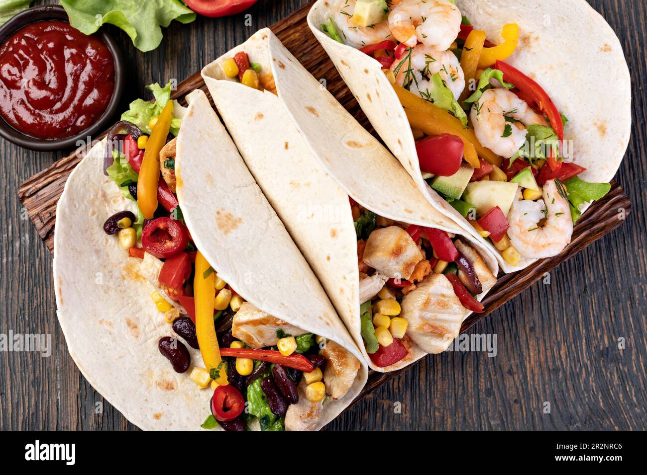 burrito with vegetables and tortilla on a wooden table Stock Photo
