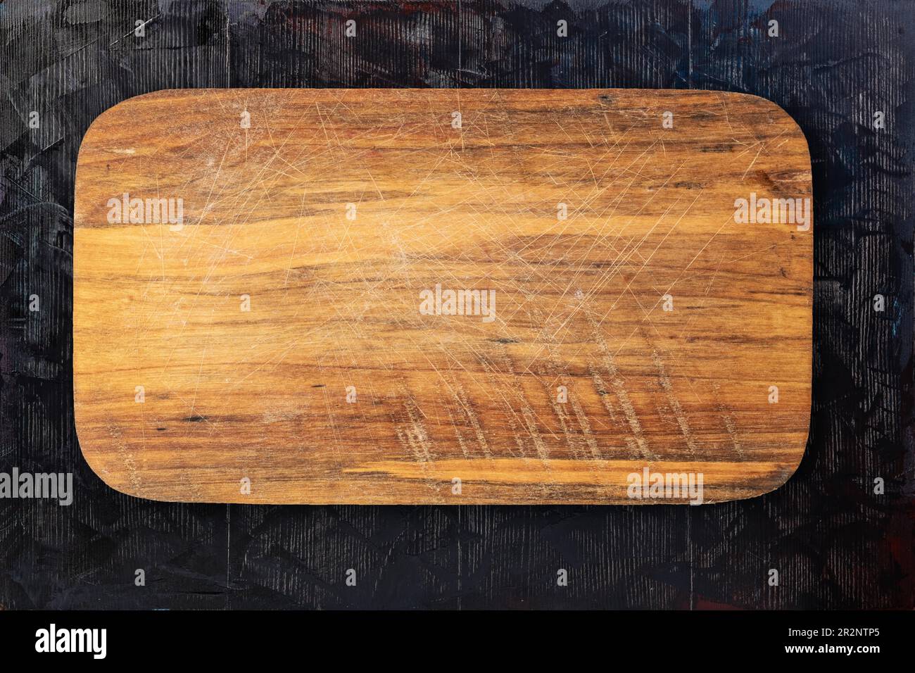 https://c8.alamy.com/comp/2R2NTP5/cutting-board-on-a-wooden-table-background-2R2NTP5.jpg