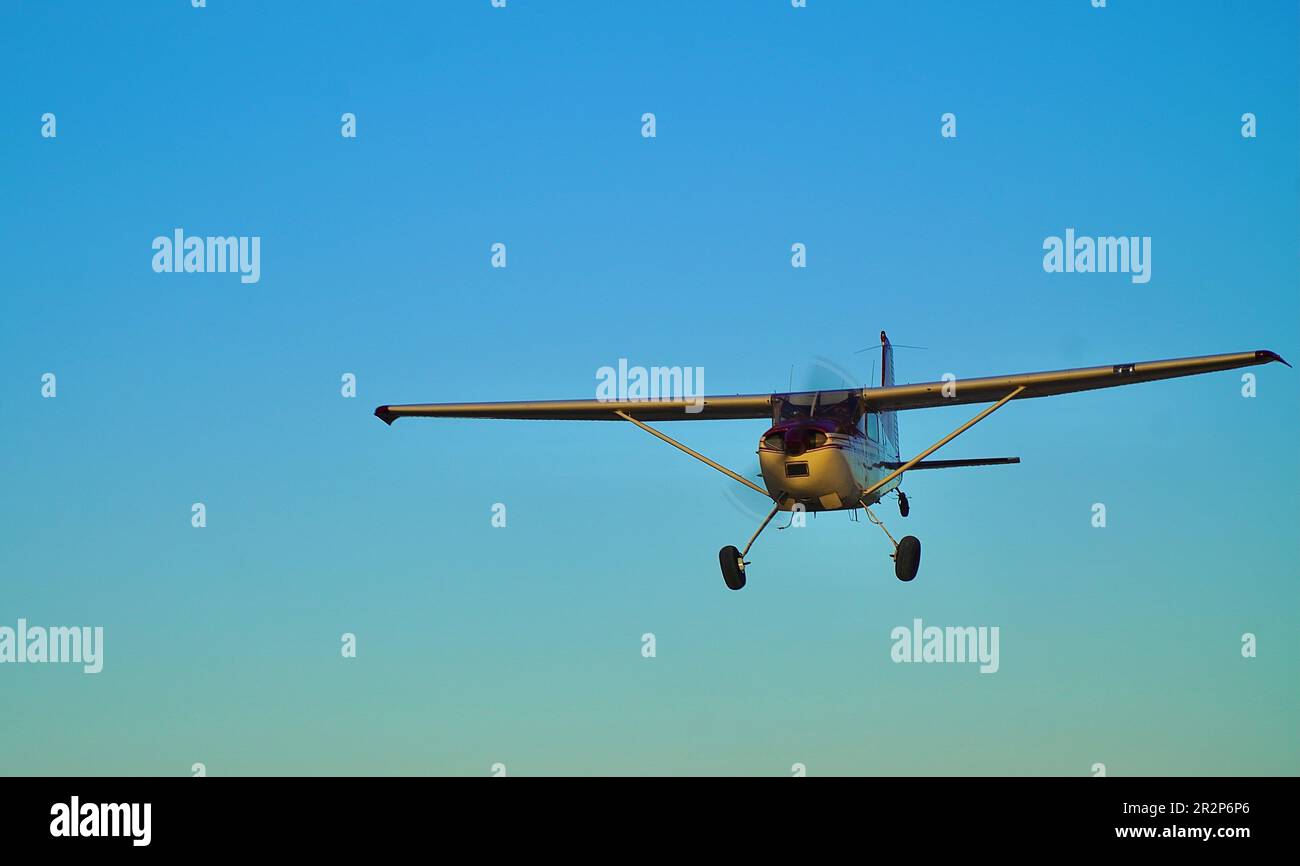 Cessna 185 plane sunset landing Stock Photo