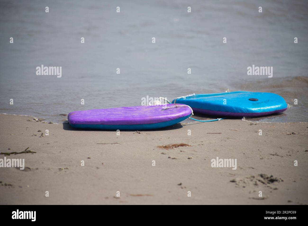 boogie board body board left abandoned on the beach object nobody copy space in front of ocean seaside Stock Photo