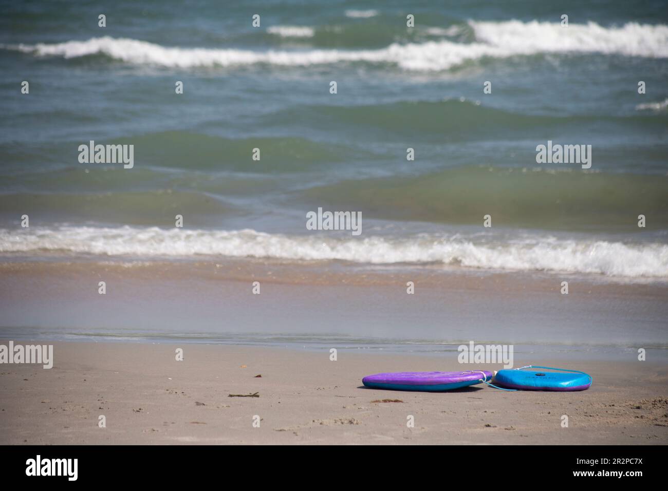 boogie board body board left abandoned on the beach object nobody copy space in front of ocean seaside Stock Photo