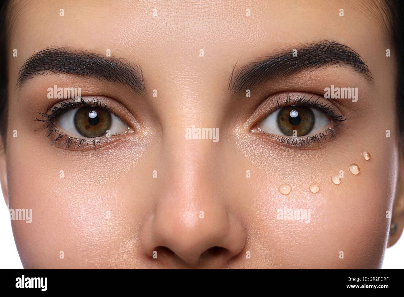 Closeup view of young woman with gel on skin under eye against white ...
