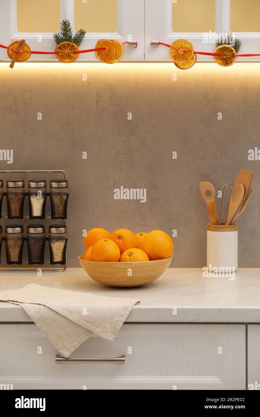 Handmade garland from dry orange slices and fir branches hanging on in kitchen Stock